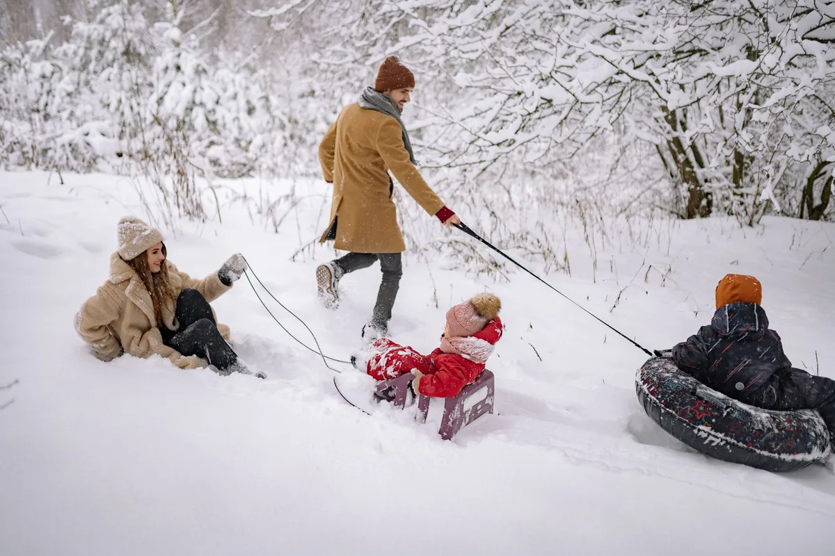 Family playing together in the snow (representative image)