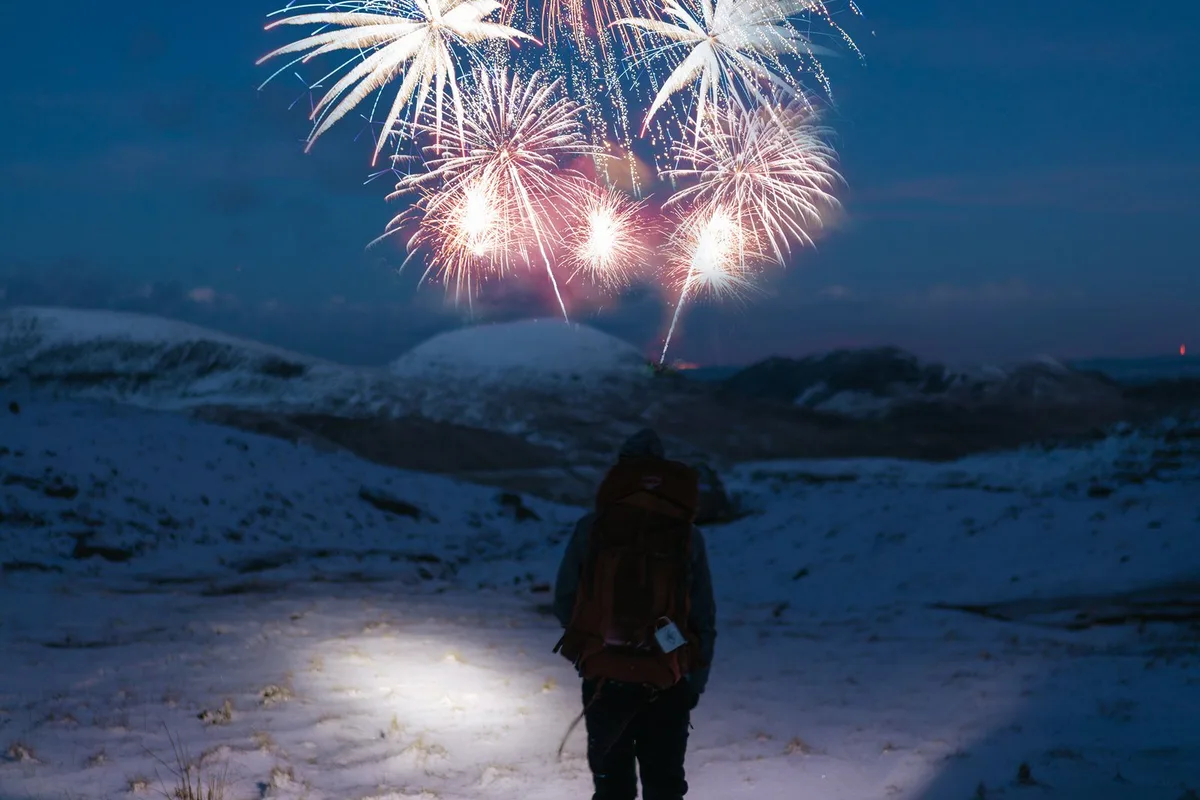 Fireworks above a snowy winter landscape (representative image)