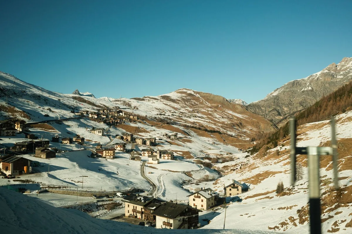 Alpine village surrounded by snowy mountains (representative image)