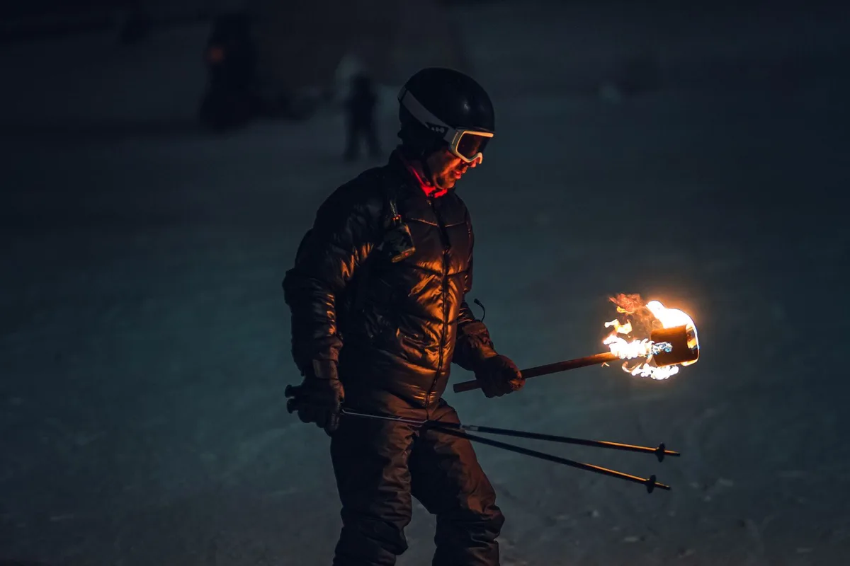 Skier holding a torch on the snow (representative image)